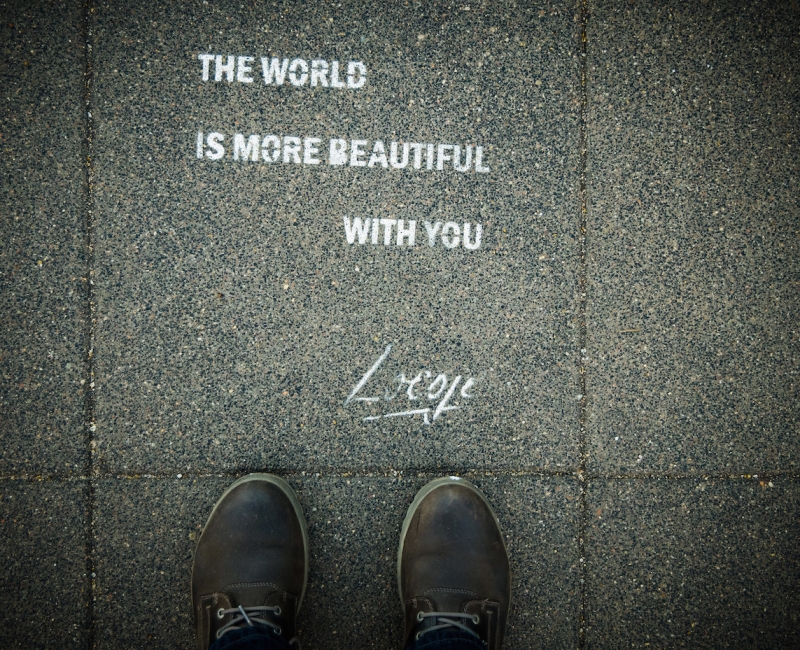 Feet with the world is more beautiful with text on ground